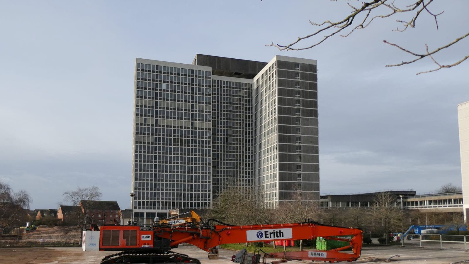 A high-reach excavator demolishing a building
